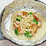 牛乳で溶いたコーンポタージュスープを加え、煮立ったら具材を中央に寄せ、溶けるチーズをのせる。