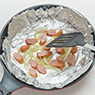 フライパンに「キチントさんフライパン用ホイルシート」を長めに切って敷き、オリーブ油を熱し、じゃがいも、ソーセージ、玉ねぎを炒める。